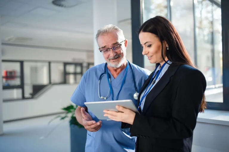 Young consultant explaining something to doctor in hospital.