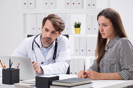 a doctor and an assistant reviewing information on a computer
