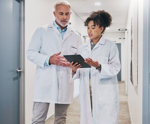 Two doctors reviewing information on a table in-between patient visits.
