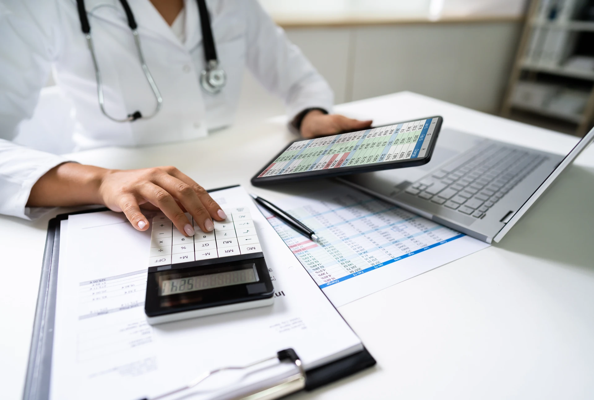 Doctor reviewing noted charts and client data from tablet.