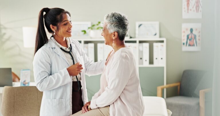 physician having a friendly conversation with a patient as she performs an exam