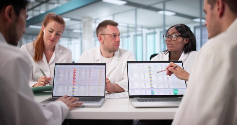 health care team reviewing docs on laptop