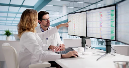 medical professionals reviewing bill codes on computer